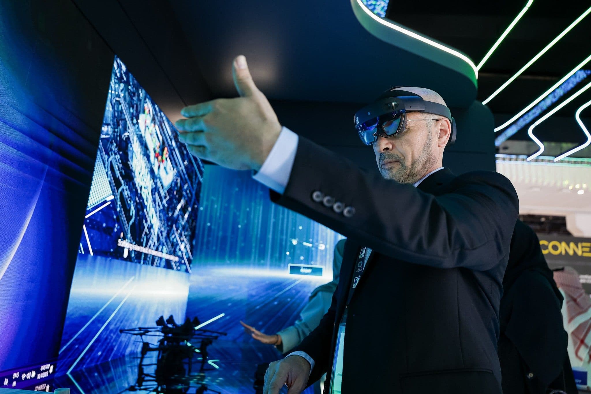 Man wearing a headset interacting with an immersive digital display.
