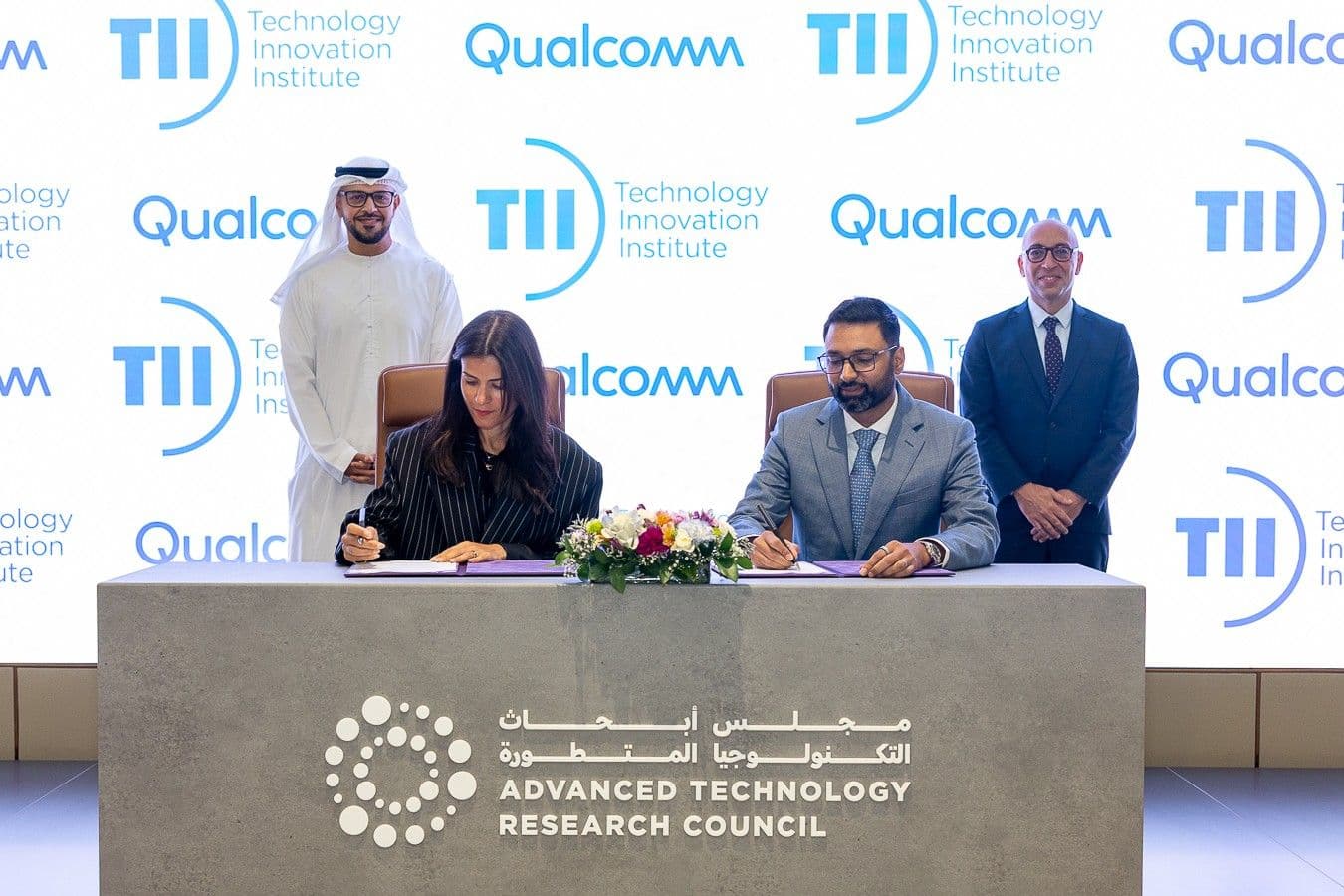 Representatives at a signing table beneath Qualcomm and Technology Innovation Institute branding.