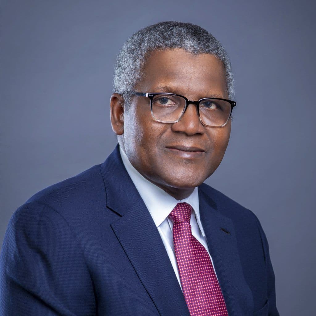 Portrait of a man wearing glasses, a blue suit, and a red tie.