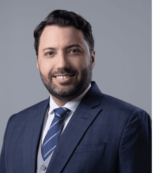 Portrait of a bearded man wearing a dark suit and tie.