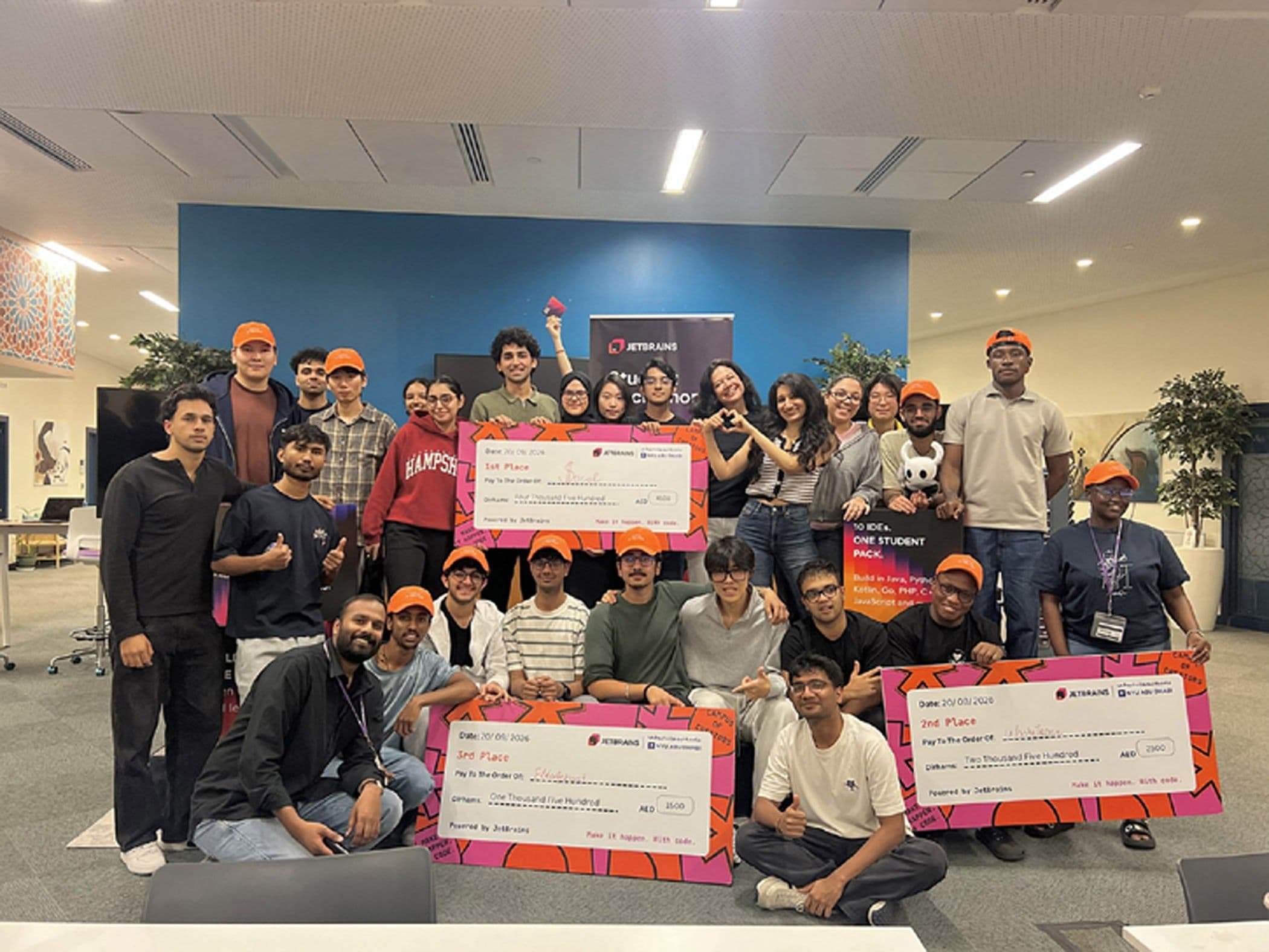 Hackathon participants posing with oversized prize checks.