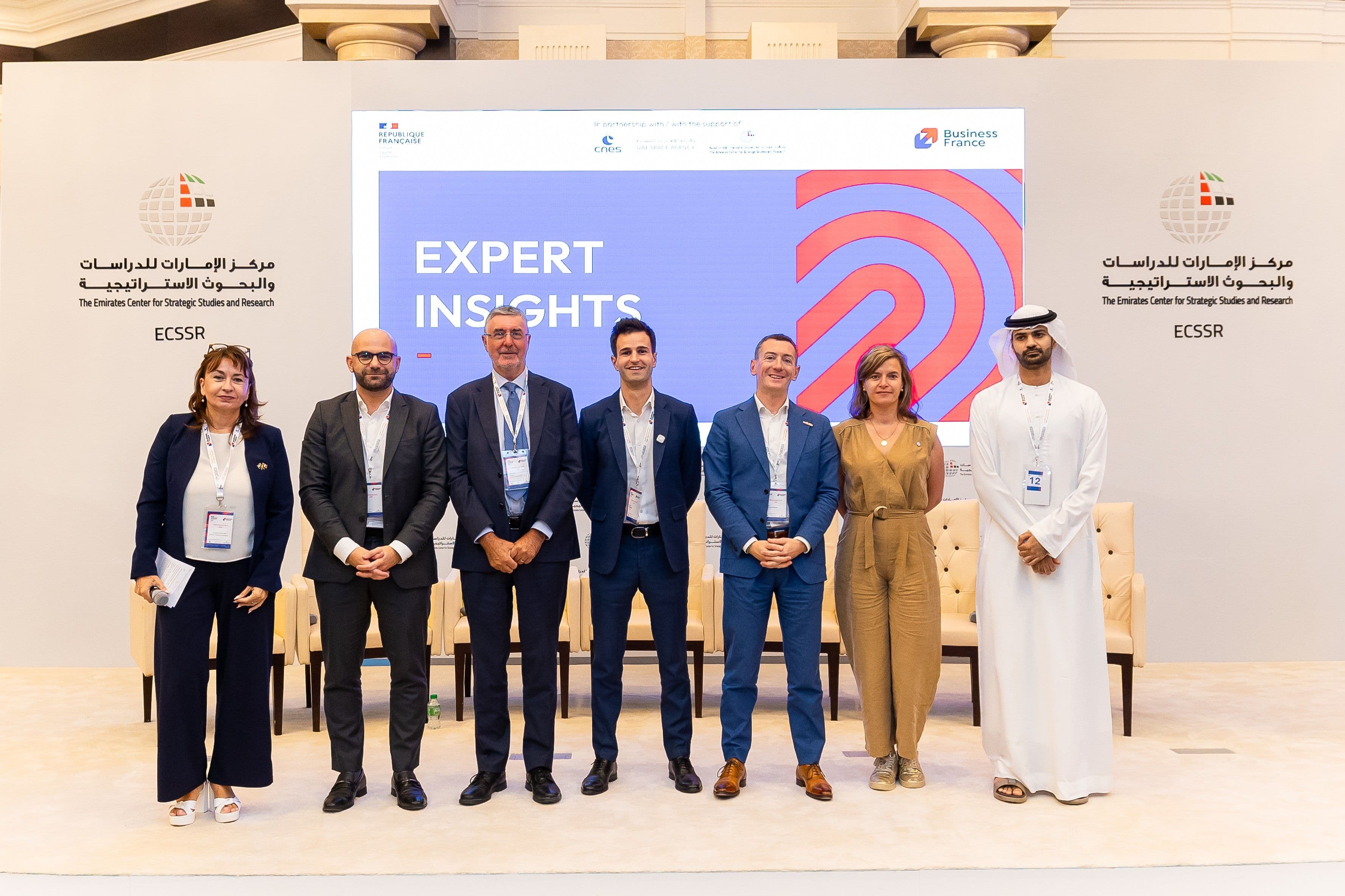 Group of representatives posing in front of an Expert Insight event display.