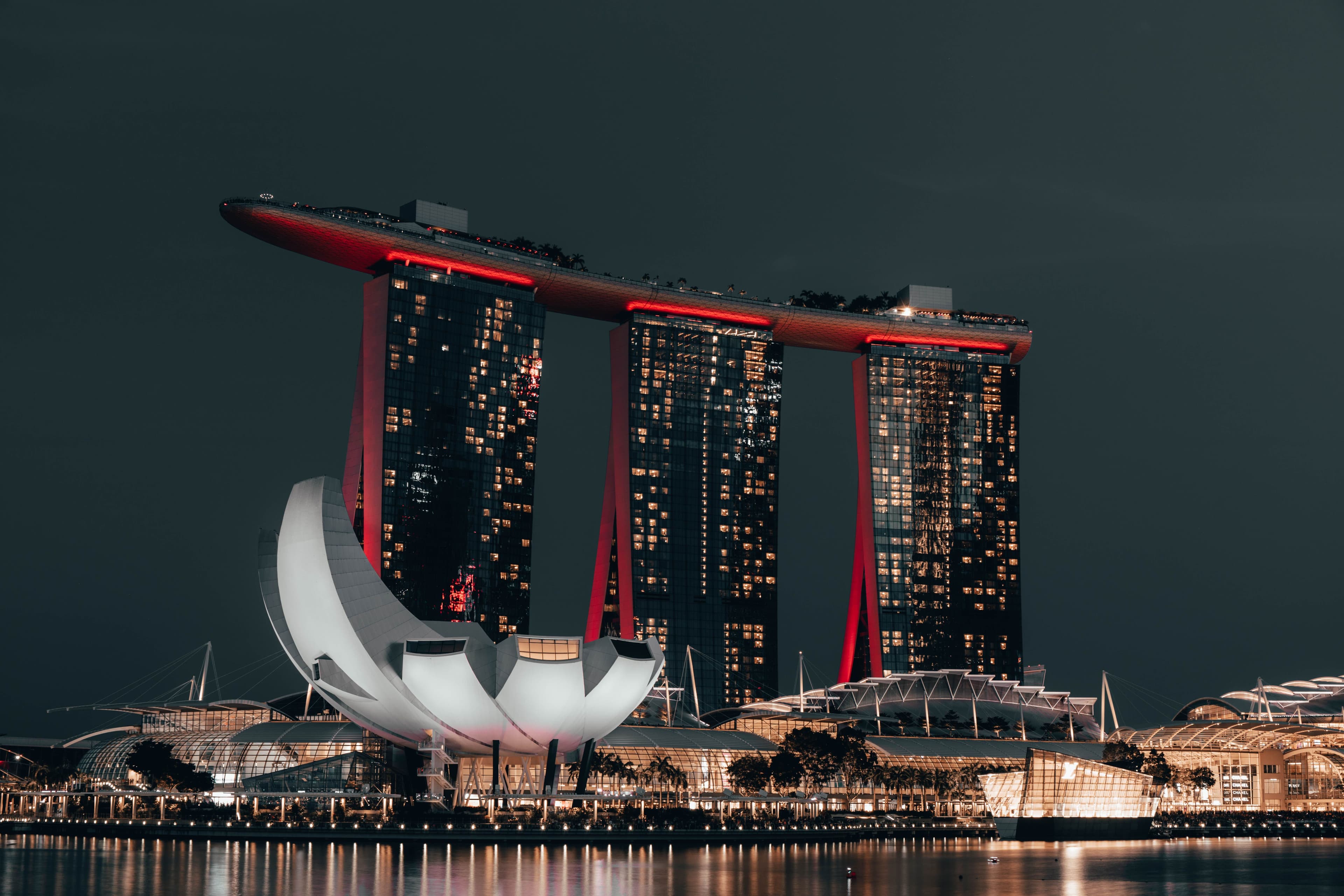 Marina Bay Sands illuminated beside the waterfront at night.