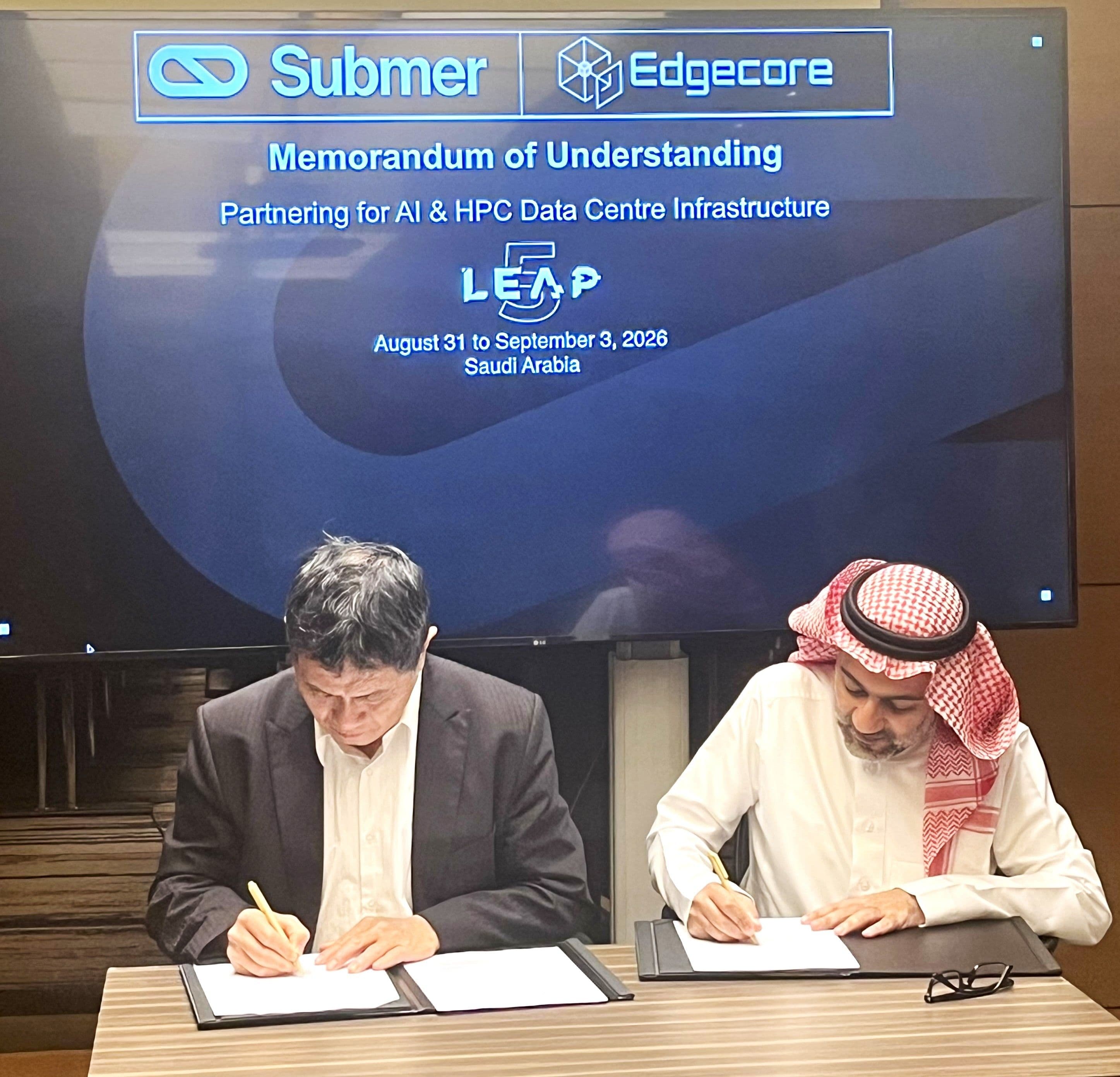 Two representatives signing an agreement beneath Submer and Edgecore branding.