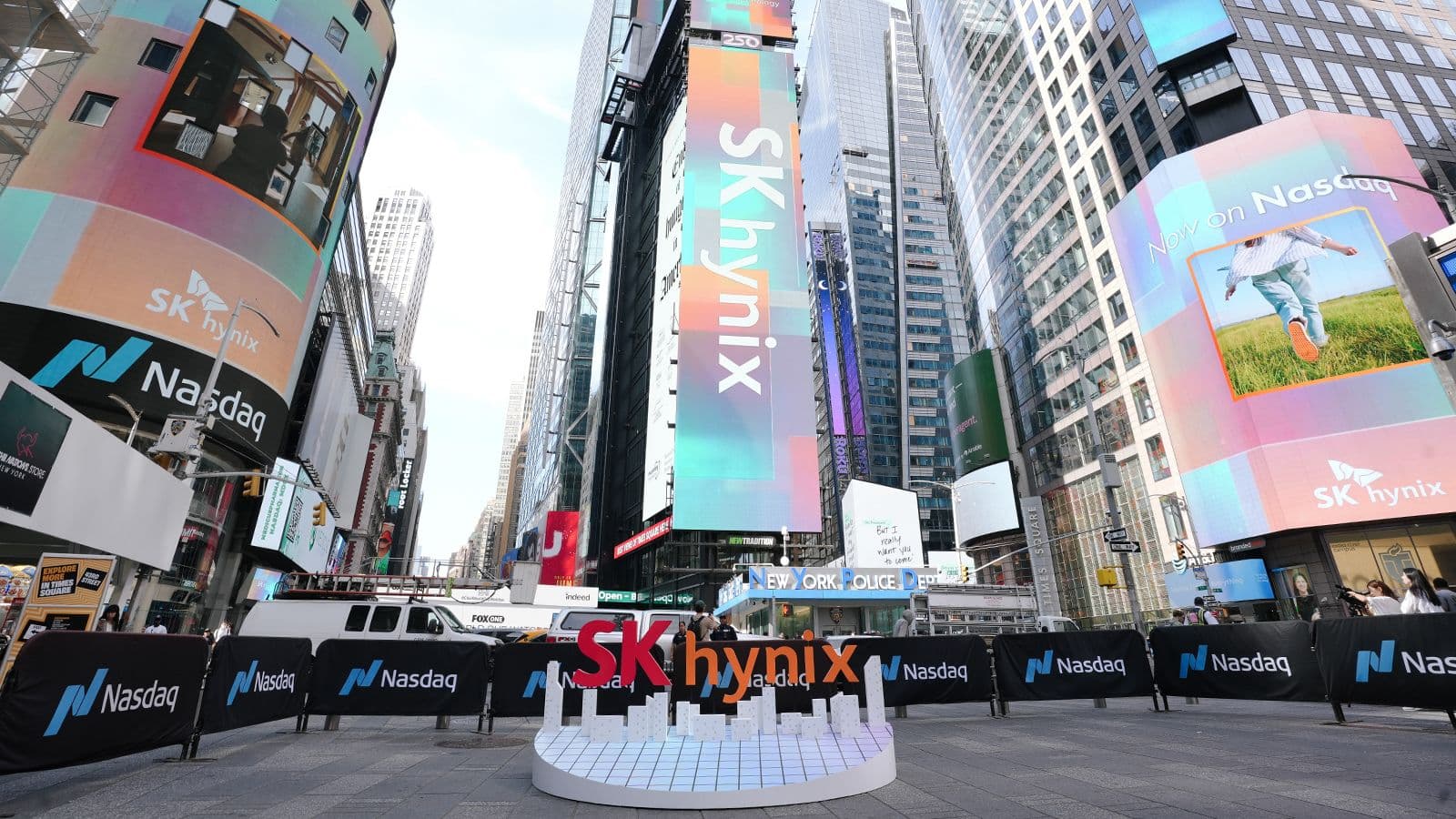 SK hynix signs among large digital billboards in a city square.