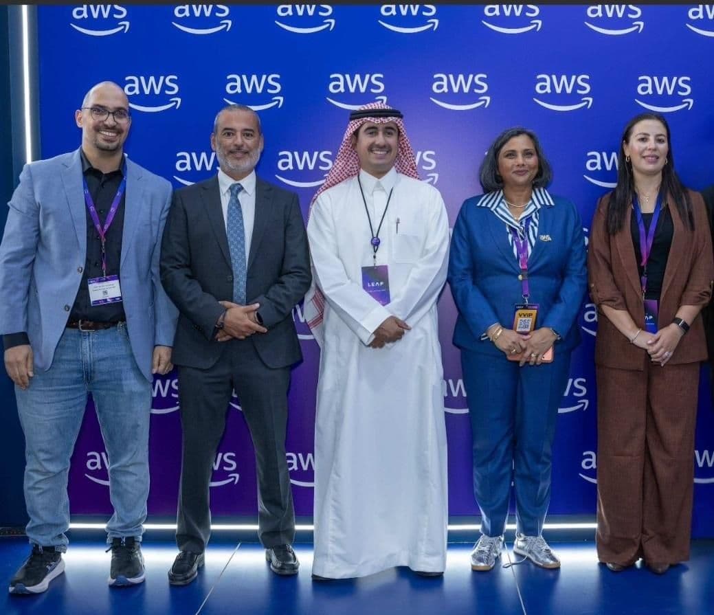 Group of representatives posing in front of AWS branding.