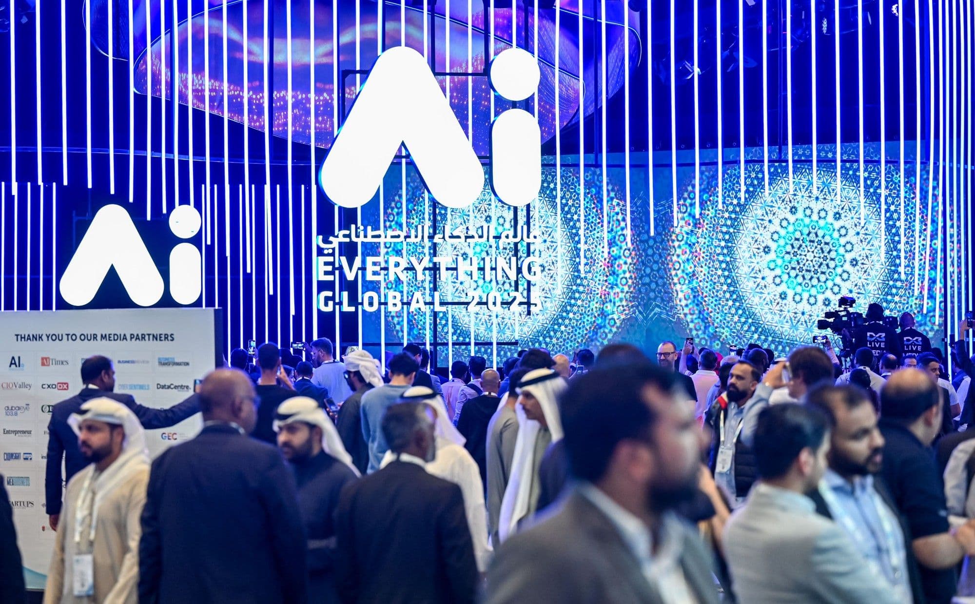 Visitors at an AI Everything exhibition beneath illuminated AI signage.