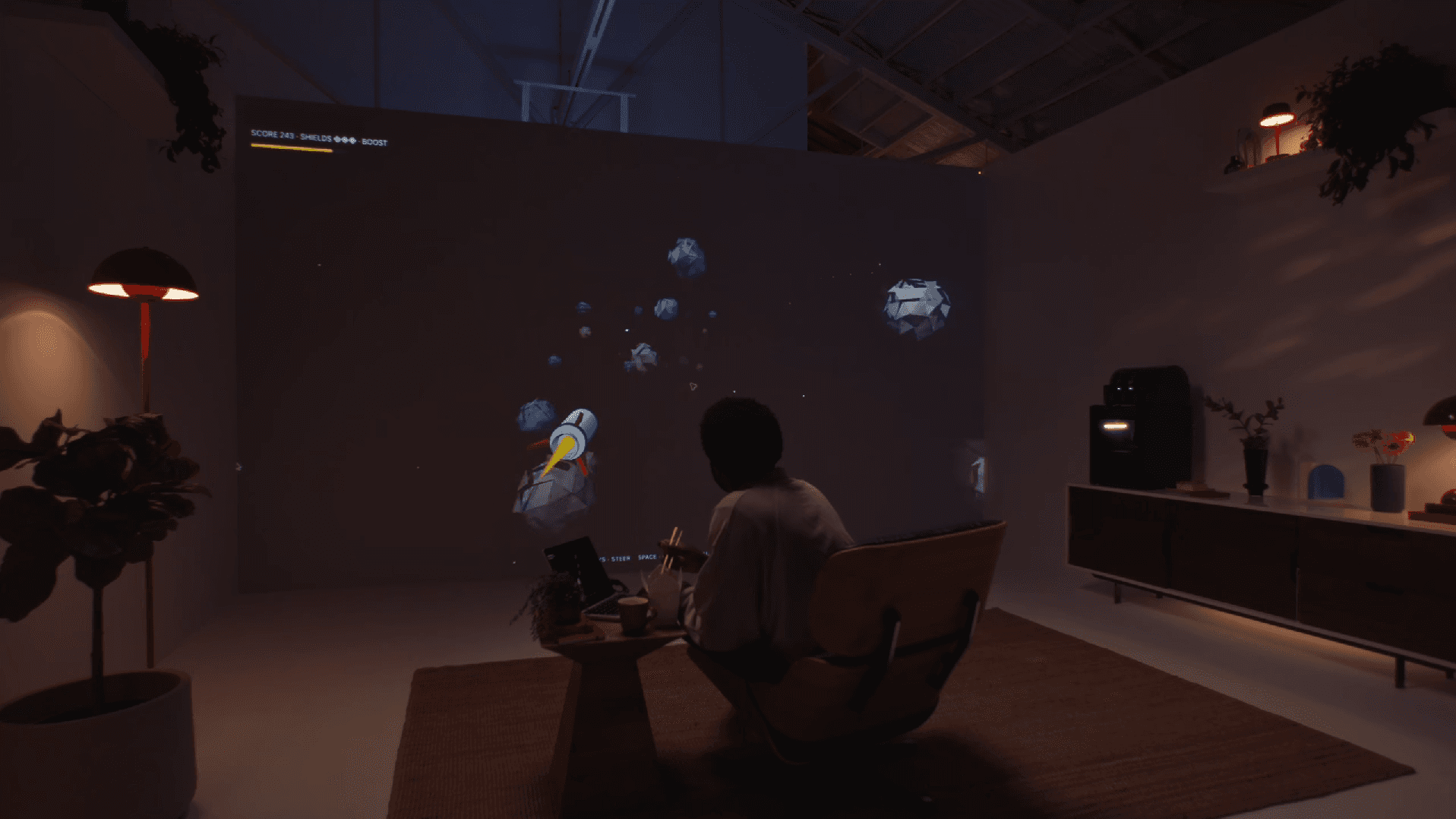 Person seated inside a dimly lit room with a large projected display.